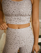 woman in pink mini moon printed cropped tank and leggings.